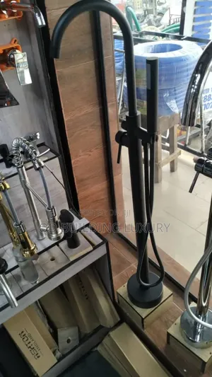 Black Floor-Mounted Freestanding Bath Mixer Tap With a Hand Shower.