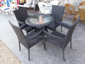 Black Rattan Outdoor Dining Set With a Glass-Top Table and Four Armcha
