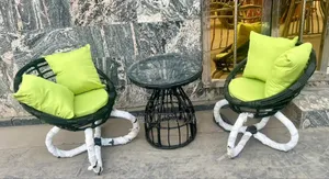 A Pair of Black Rattan Chairs With a Round Rattan Centre Table