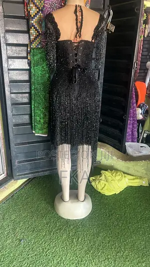 A Fitted Black Knee-Length Dress With a Neckline, Covered in Beads.