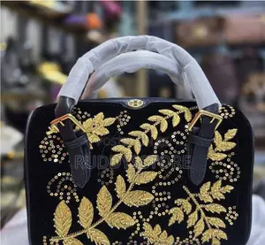 Tory Burch Monogram Embellished Barrel Bag.
