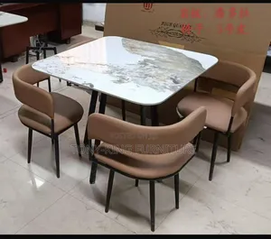 Modern Dining Table With A Marble Top And Black Upholstered Chairs.