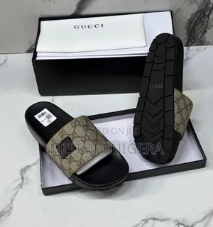 And Ebony Gg Canvas Gucci Slides With a Black Rubber Sole.