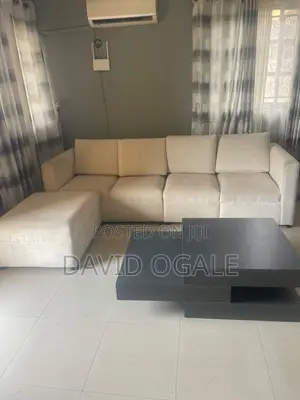 L Shape Sofa With an Ottoman Attached to It.