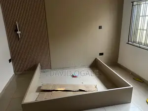 A Tan Colored Rectangular 6 by 6 Wooden Bed Frame