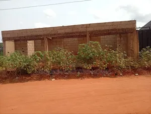 Here We Have Empty Plot of Land With 3 Shops in Front of It at Emene.