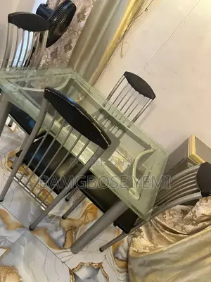 A Thick Glass Dinning Table With Four Chairs
