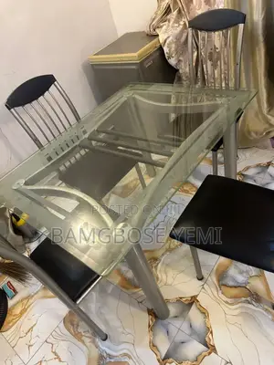 A Thick Glass Dinning Table With Four Chairs