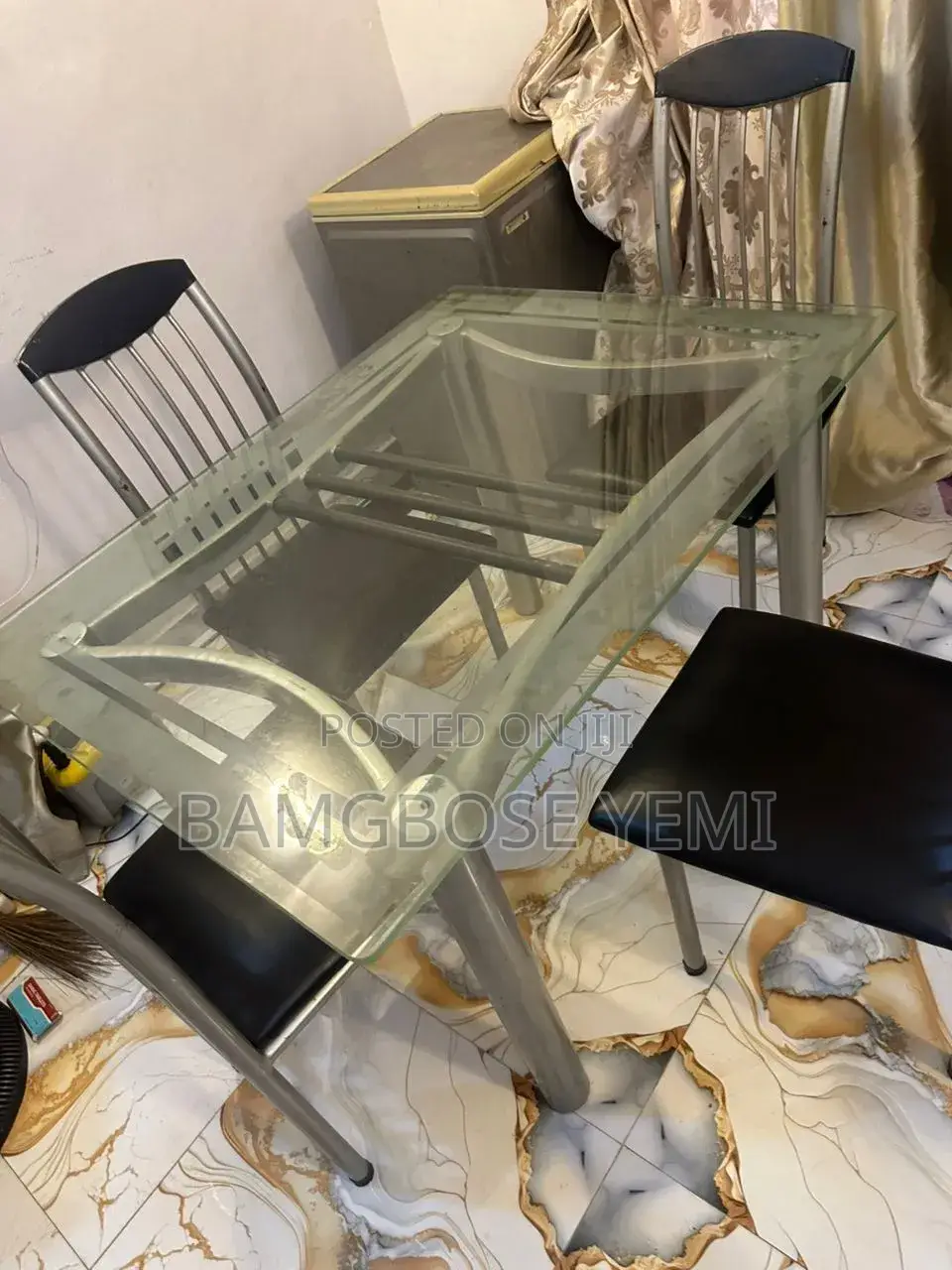 A Thick Glass Dinning Table With Four Chairs
