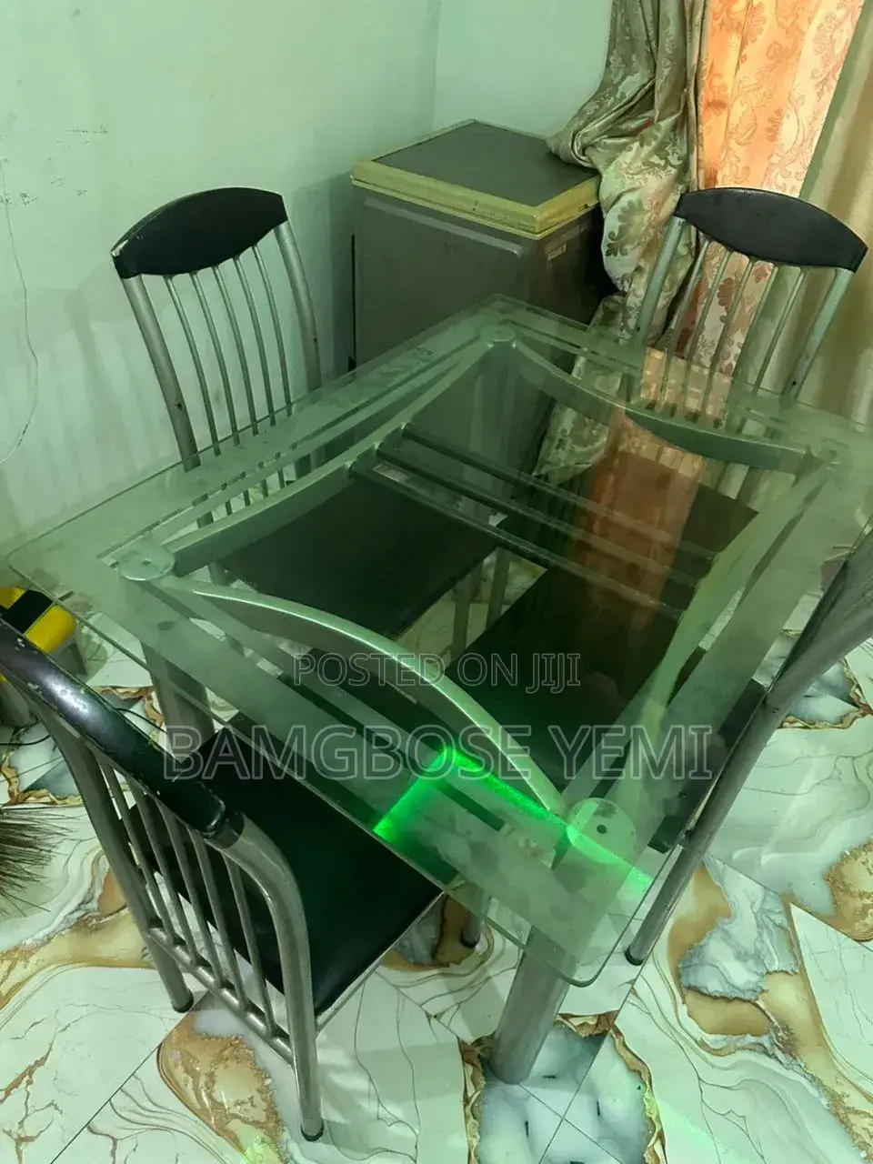 A Thick Glass Dinning Table With Four Chairs