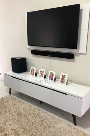 A Modern Wall-Mounted Tv Setup With a Sleek White Media Console
