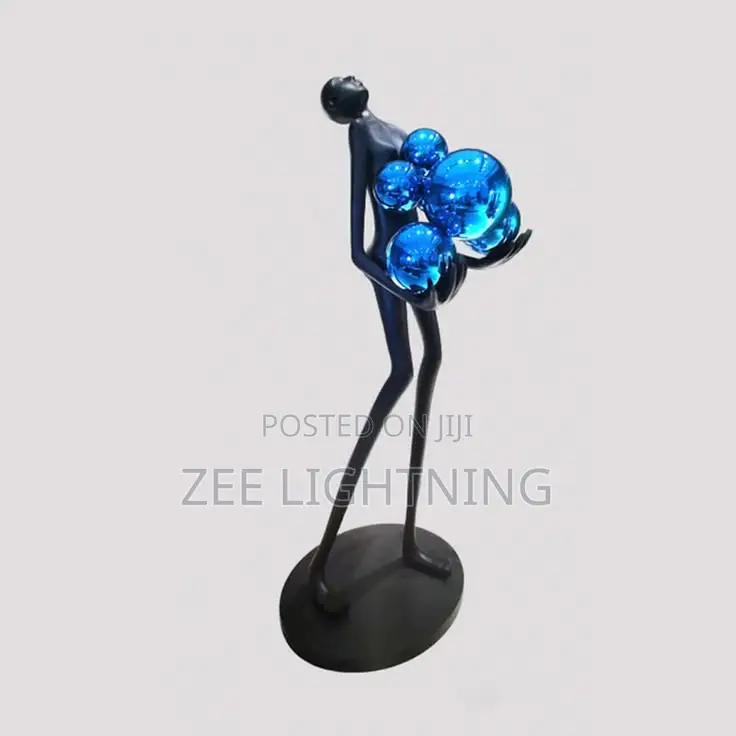 Humanoid Sculpture Carrying Silver and Blues Balls