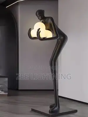 Humanoid Sculpture Carrying Silver and Blues Balls