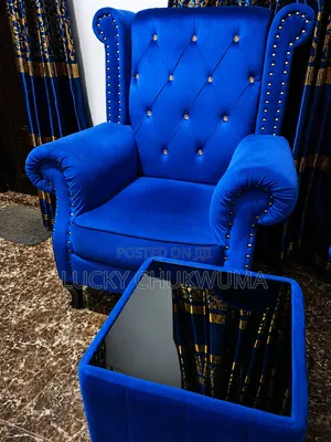 A One Seater Modern Blue Velvet Chair With a Glass Top Side Stool.