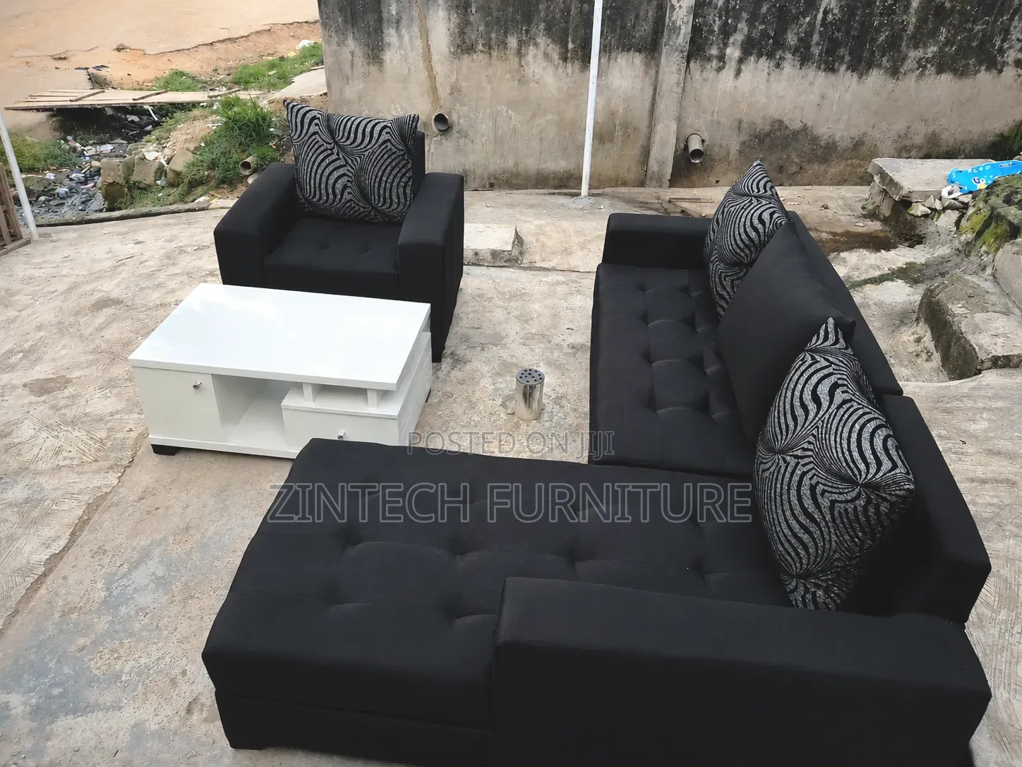 Black L Shape Sofas and a White Table