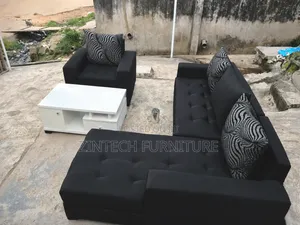 Black L Shape Sofas and a White Table