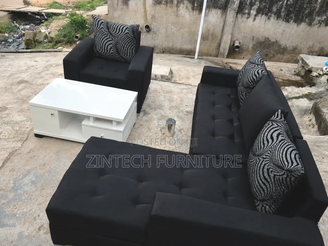 Black L Shape Sofas and a White Table