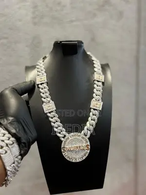 Cuban Link Chain With a Round Iced-Out “HUSTLE” Pendant.