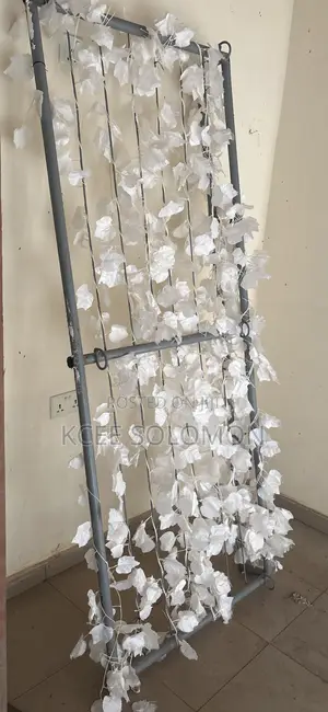 This Item Is a Metal Backdrop Stand With Hanging White Artificial Leaf