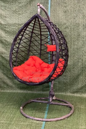 Black Rattan Hanging Egg Chair Accented With Vibrant Red Cushions.