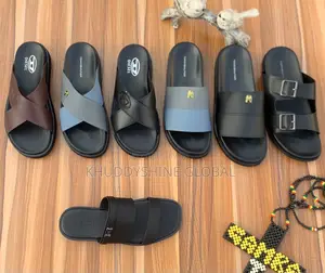 Men's Designer-Style Slip-on Sandals and Slides Arranged on a Wooden