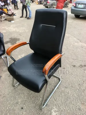 Black Leather Visitor Office Chair Featuring Polished Wooden Armrests.