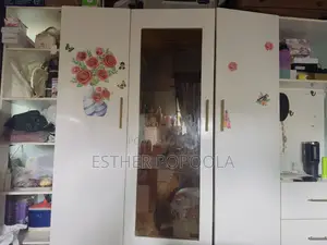 Large White Wooden Wardrobe With Multiple Storage Sections.
