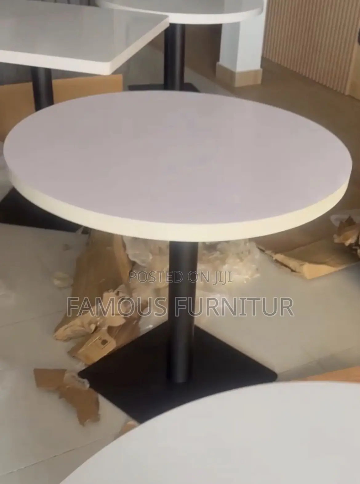 Modern Round Pedestal Restaurant Table With a White Top Square Base.