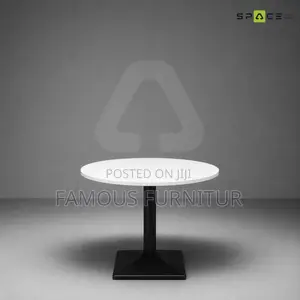 Modern Round Pedestal Restaurant Table With a White Top Square Base.