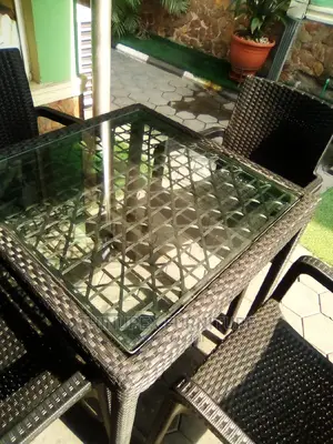 A Set of Plastic Cane Chairs With Glass Top Table